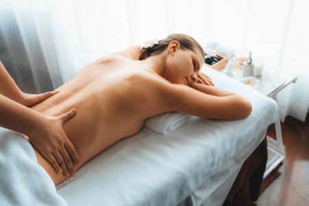 Caucasian woman customer enjoying relaxing anti-stress spa massage and pampering with beauty skin recreation leisure in day light ambient salon spa at luxury resort or hotel. Quiescentの写真素材