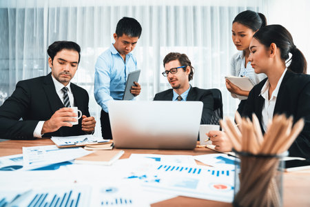 Diverse group of business analyst team analyzing financial data report paper on office table. Chart and graph dashboard by business intelligence analysis for strategic marketing planning Habilimentの写真素材