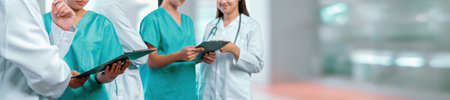 Medical staff team with doctor nurse and specialist working together with laptop and tablet on blur...