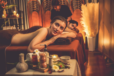 Couple customer having exfoliation treatment in luxury spa salon with warmth candle light ambient....