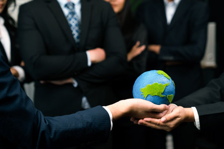 Top view business people holding Earth together in synergy as team building to utilize eco regulation for environmental protection by reducing CO2 emission to save Earth. Quaintの写真素材