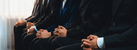 Asian job applicant waiting in line with good manners hand gesture and identical black formal wear for job interview. Modern and professional job seeker concept. Trailblazingの写真素材