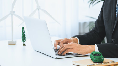 Businessman working in office developing plan or business project on eco-friendly ev car using net zero alternative energy technology on computer for greener environment as apart of CSR effort. Gyreの写真素材