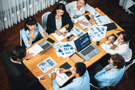 Wide top view of diverse group of business analyst team analyzing financial data report paper on meeting table. Chart and graph dashboard by business intelligence analysis. Meticulousの写真素材