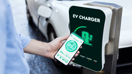 Businessman holding smartphone display battery status interface by smart EV mobile application while...