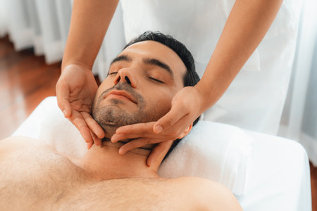 Caucasian man enjoying relaxing anti-stress head massage and pampering facial beauty skin recreation leisure in dayspa modern light ambient at luxury resort or hotel spa salon. Quiescentの写真素材