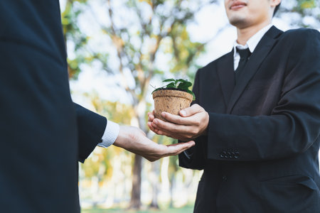 Business people holding plant as concept of eco company committed to corporate social responsible, reducing CO2 emission, protect environment, and embrace ESG principle for sustainable future. Gyreの写真素材