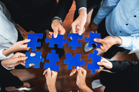 Top view multiethnic business people holding jigsaw pieces and merge them together as effective solution solving teamwork, shared vision and common goal combining diverse talent. Meticulousの写真素材