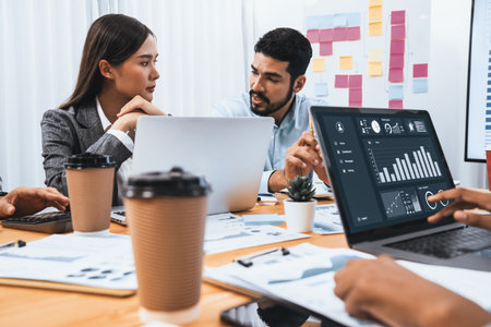 Multiracial analyst team use BI Fintech software to analyze financial data on meeting table....