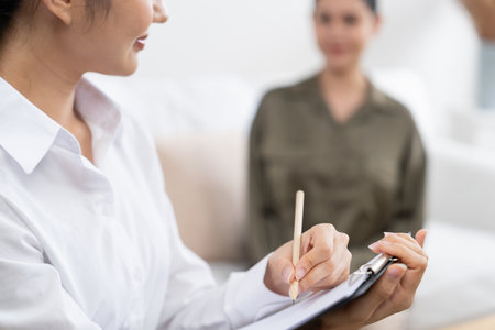 Happy patient and psychologist have mental health conversation in clinic with positive emotion while explaining uttermost successful work and life to psychologist in home office .の写真素材