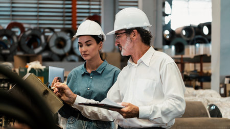 Metalwork manufacturing factory manager inspecting industrial steel machinery and overseeing while supervising and enhancing quality control process for metal material product. Panorama Exemplifyingの写真素材