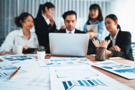 Focus financial data dashboard paper by business intelligence display graph, chart and statistic report on office table with blurred business people working in background. Habilimentの写真素材
