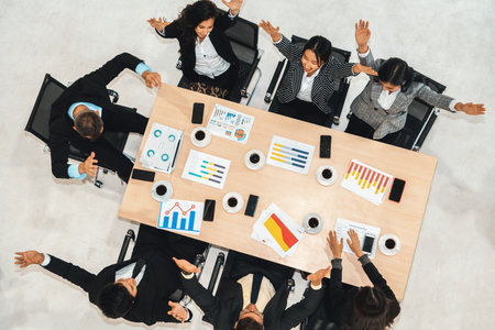 Successful business people celebrate together with joy at office table shot from top view . Young...