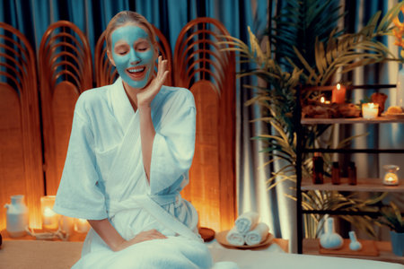 Serene ambiance of spa salon, woman customer indulges in rejuvenating with luxurious face cream massage with warm lighting candle. Facial skin treatment and beauty care concept. Quiescentの写真素材