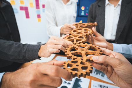 Office worker holding cog wheel as unity and teamwork in corporate workplace concept. Diverse colleague business people showing symbol of visionary system and mechanism for business success. Concordの写真素材