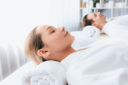 Caucasian couple customer enjoying relaxing anti-stress spa massage and pampering with beauty skin recreation leisure in day light ambient salon spa at luxury resort or hotel. Quiescentの写真素材