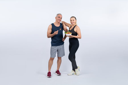 Happy smile senior man and woman portrait holding bowl of vegan fruit and vegetable on isolated background. Healthy senior couple with healthy vegetarian nutrition and body care lifestyle. Cloutの写真素材