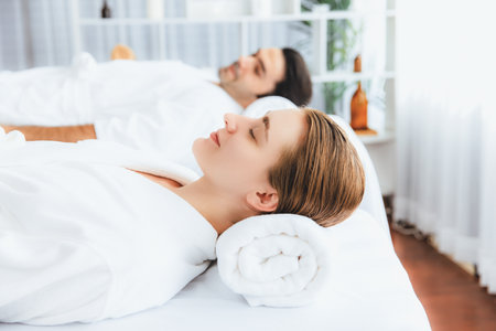 Caucasian couple customer enjoying relaxing anti-stress spa massage and pampering with beauty skin recreation leisure in day light ambient salon spa at luxury resort or hotel. Quiescentの写真素材