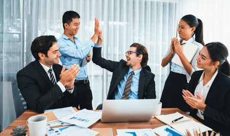 Group of happy businesspeople in high five gesture and successful efficient teamwork. Diverse race office worker celebrate after made progress on marketing planning in corporate office. Habilimentの写真素材