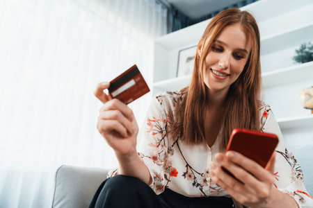 Young happy woman buy product by online shopping at home while ordering items from the internet with...
