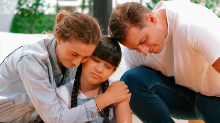 Parents comforting their daughter with loving hug, helping her feel secure and protected from fear, rest her head on shoulder and sadness melts away. Family love and child care Panorama. Synchronosの写真素材