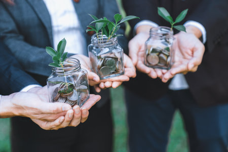 Concept of sustainable money growth investment with glass jar filled with money savings coins with businesspeople as eco-friendly financial investment nurtured with nature and healthy retirement. Gyreの写真素材