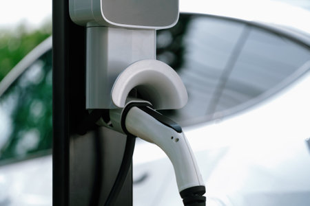 Closeup EV charging station with electric charger plug connected to charging platform power sauce. Alternative clean and sustainable energy for eco-friendly EV car for better future. Synchronosの写真素材