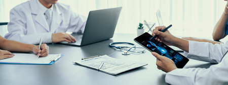 Doctor and nurse in medical meeting discussing strategic medical treatment plan together with report and laptop. Medical school workshop training concept in panoramic banner. Neotericの写真素材