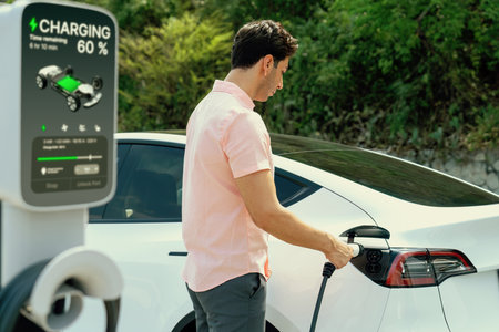 Holiday road trip vacation traveling by the nature countryside with electric car, man recharge EV...