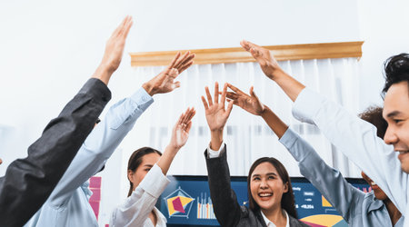Diverse business team celebrate successful meeting with high-fives and expressions of happiness in corporate office meeting represent unity success and professional integrity. Concordの写真素材
