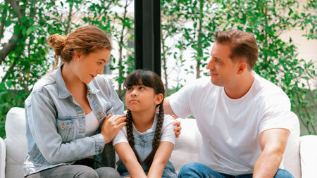 Parents comforting their daughter with loving hug, helping her feel secure and protected from fear, rest her head on shoulder. Happy family love and child care support concept. Synchronosの写真素材