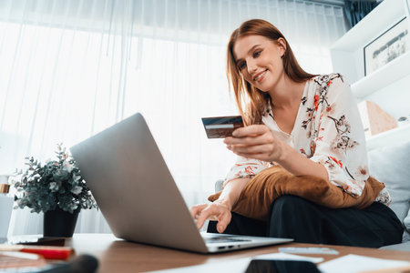 Young happy woman buy product by online shopping at home while ordering items from the internet with credit card online payment system protected by utmost cyber security from online store platformの写真素材