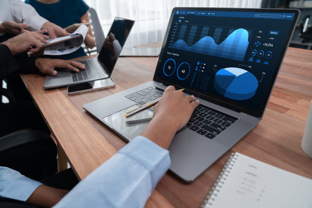 Multiracial analyst team use BI Fintech software to analyze financial data on meeting table. Financial dashboard data display on laptop screen with analyzed chart for marketing indication. Concordの写真素材