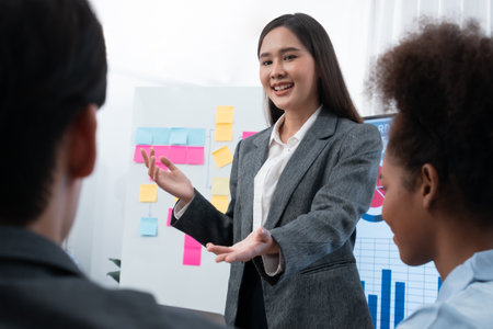 Young asian businesswoman presenting data analysis dashboard on TV screen in modern meeting. Business presentation with group of business people in conference room. Concordの写真素材