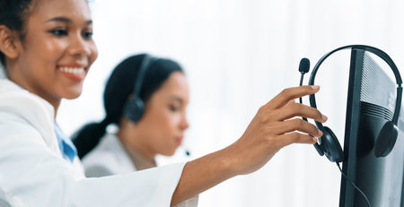 Business people wearing headset working in office to support remote customer or colleague. Call center, telemarketing, customer support agent provide service on telephone video conference call crucialの写真素材