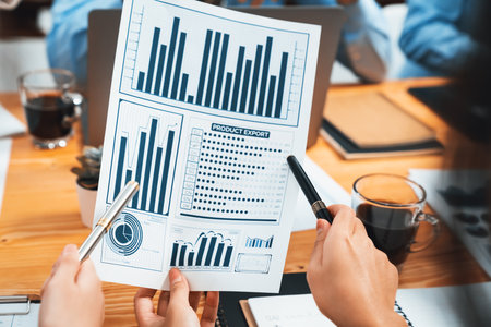 Diverse group of business analyst team analyzing financial data report paper on office table. Chart...