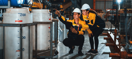 Two factory workers or engineers conduct professional inspection on machine or procedure in chemical plant, chemistry factory workplace and industrial profession concept. Panorama Exemplifyingの写真素材