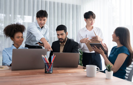 Happy diverse business people work together, discussing in corporate office. Professional and diversity teamwork discuss business plan on desk with laptop. Modern multicultural office worker. Concordの写真素材