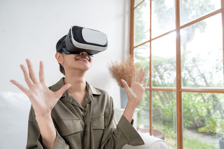 Young woman using virtual reality VR goggle at home for uttermost online shopping experience. The...