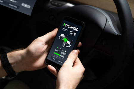 Electric car driver checks battery charging status, range and charging limit on app screen in the...