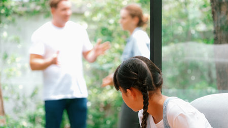 Stressed and unhappy young girl huddle in corner crying and sad while her parent arguing in background. Domestic violence at home and traumatic childhood develop to depression. Panorama Synchronosの写真素材