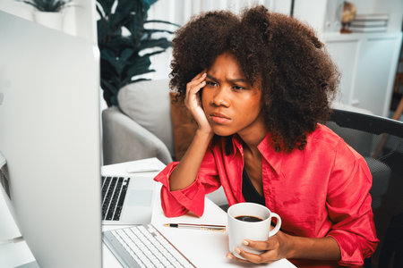Young African businesswoman focusing project on screen monitor laptop, researching information data...