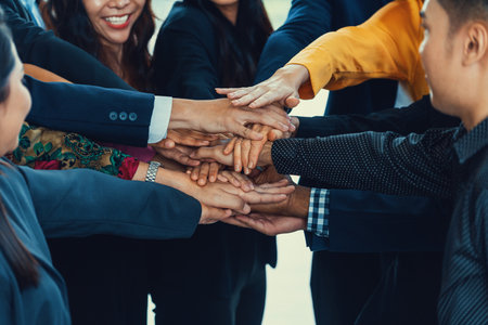 A group of diversity people putting their hands together. Showing unity teamwork and friendship. Close up side view of young business man and business woman joining as a team. Intellectual.の写真素材