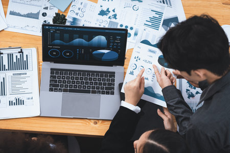 Multiracial analyst team use BI Fintech software to analyze financial data on meeting table. Financial dashboard data display on laptop screen with analyzed chart for marketing indication. Concordの写真素材