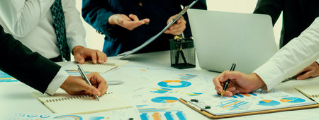 Business people in group meeting in formal attire share idea discussing report for company profit in...