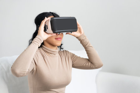 Young woman using virtual reality VR goggle at home for crucial online shopping experience. The...