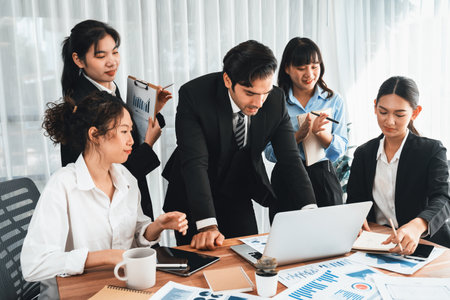 Diverse group of business analyst team analyzing financial data report paper on office table. Chart and graph dashboard by business intelligence analysis for strategic marketing planning Meticulousの写真素材