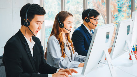 Business people wearing headset working in office to support remote customer or colleague. Call center, telemarketing, customer support agent provide service on telephone video conference call. Jivyの写真素材