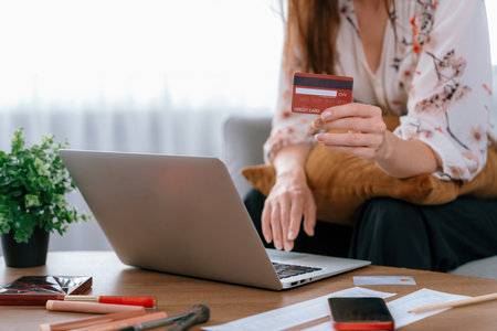 Young happy woman buy product by online shopping at home while ordering items from the internet with credit card online payment system protected by utmost cyber security from online store platformの写真素材