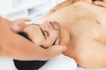 Caucasian man enjoying relaxing anti-stress head massage and pampering facial beauty skin recreation leisure in dayspa modern light ambient at luxury resort or hotel spa salon. Quiescentの写真素材